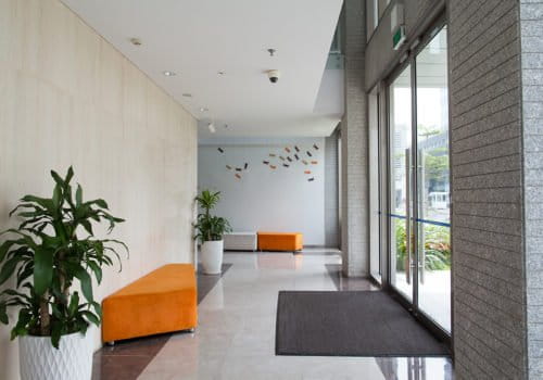 Empty entrance of condominium building. Glass doors and hall of hotel building. Living space concept