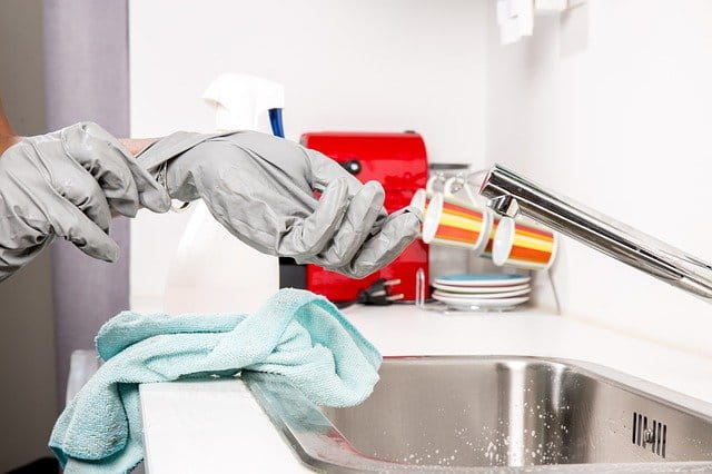 Une personne enfilant ses gants de nettoyage.