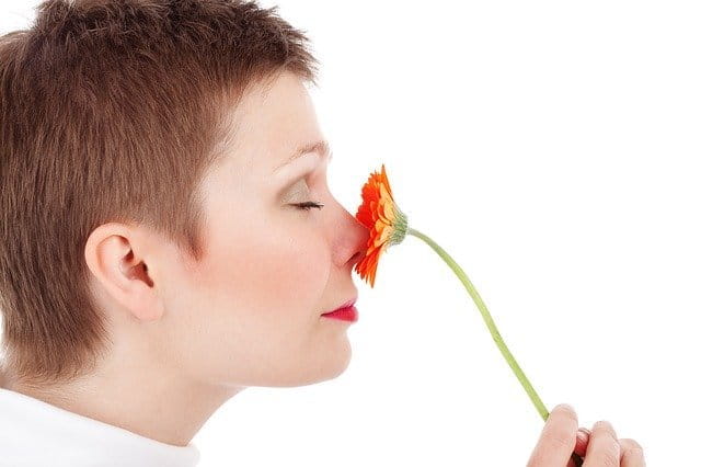 Femme adulte qui sent une fleur