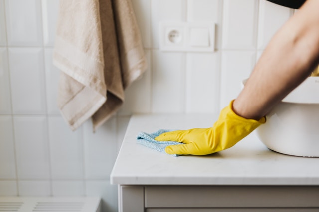 Agent d'entretien en plein travail dans une salle de bain.